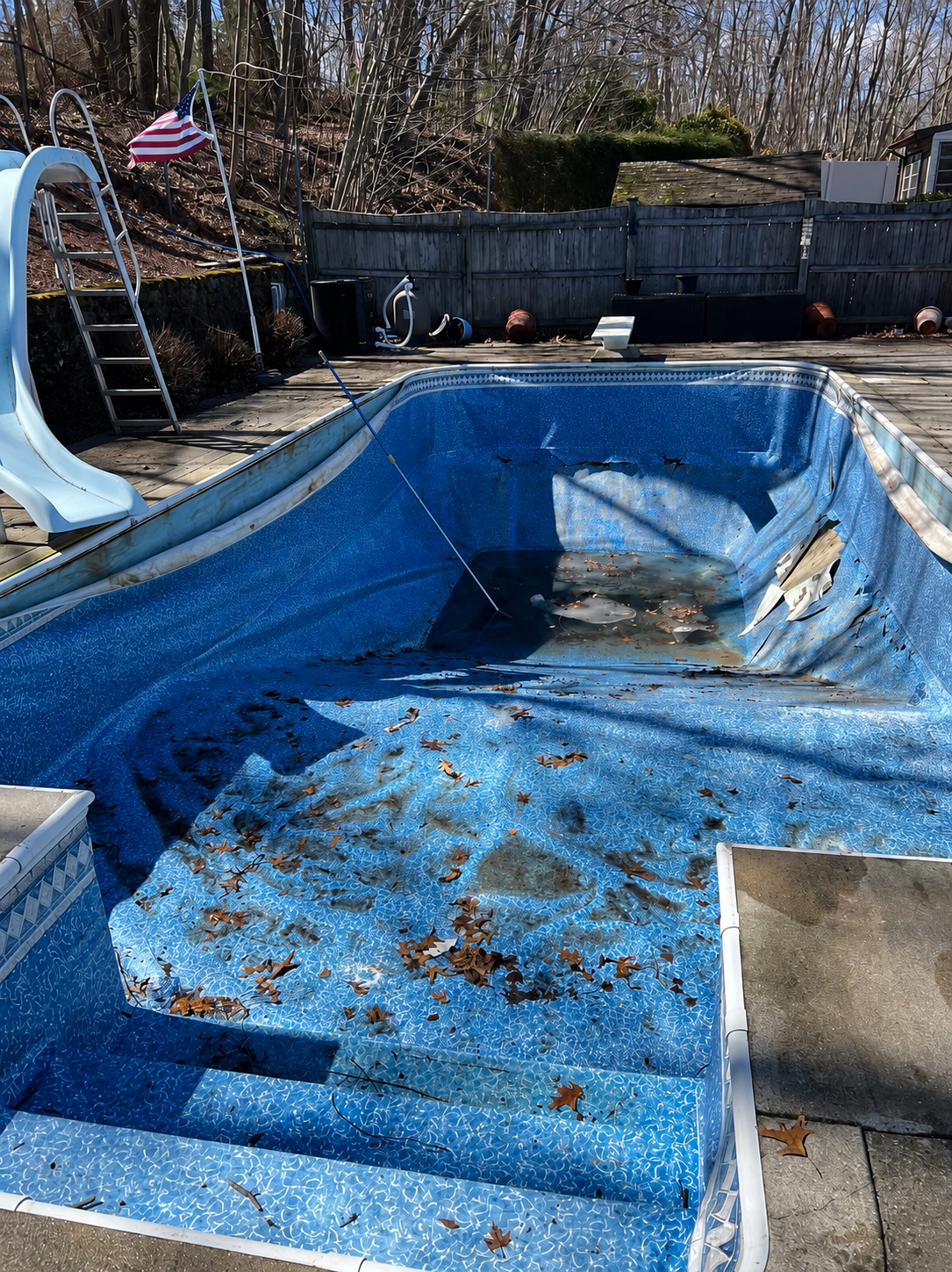 Inground pool before liner replacement — torn and deteriorated vinyl liner
